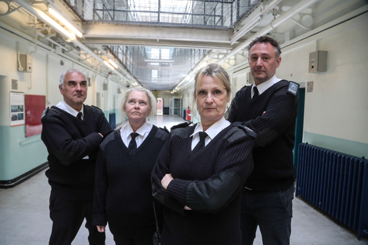 Four prison officers standing on the wing
